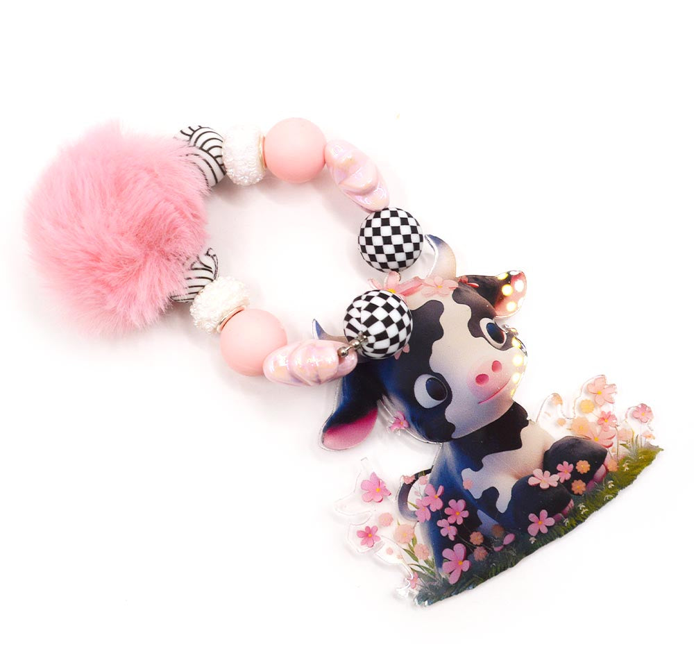 Assortment of silicone cow themed beads with charms and puff ball.