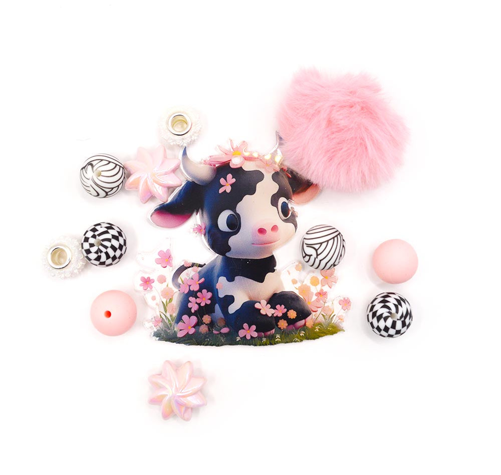 Assortment of silicone cow themed beads with charms and puff ball.