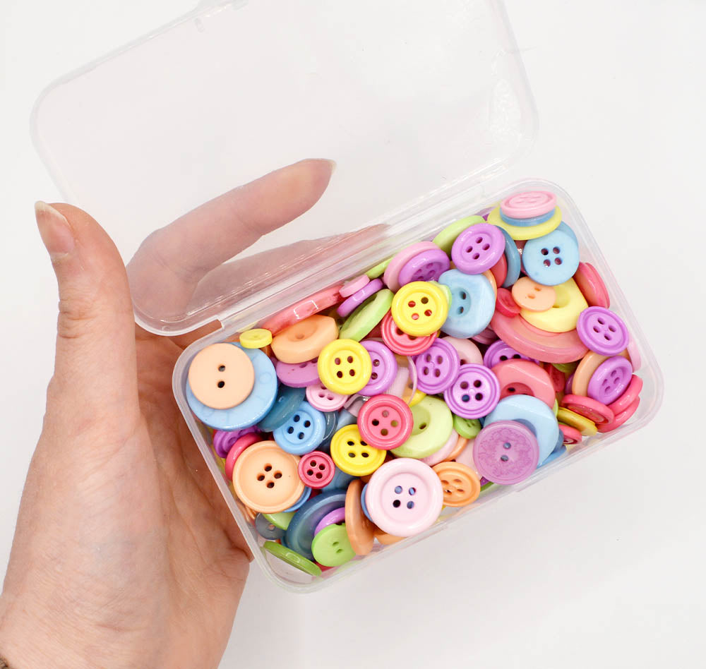 Assortment of sewing buttons in pastel rainbow tones in various sizes and styles.