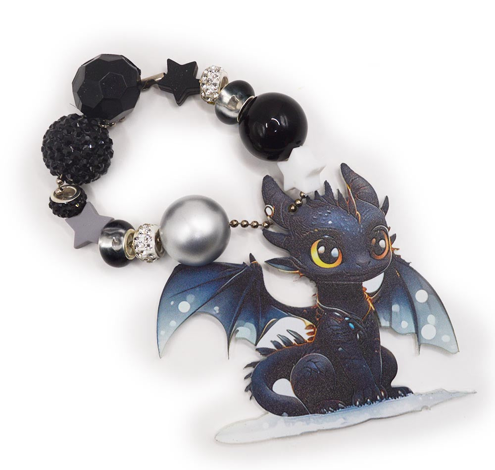 Assortment of silicone black and white dragon themed beads with charms.