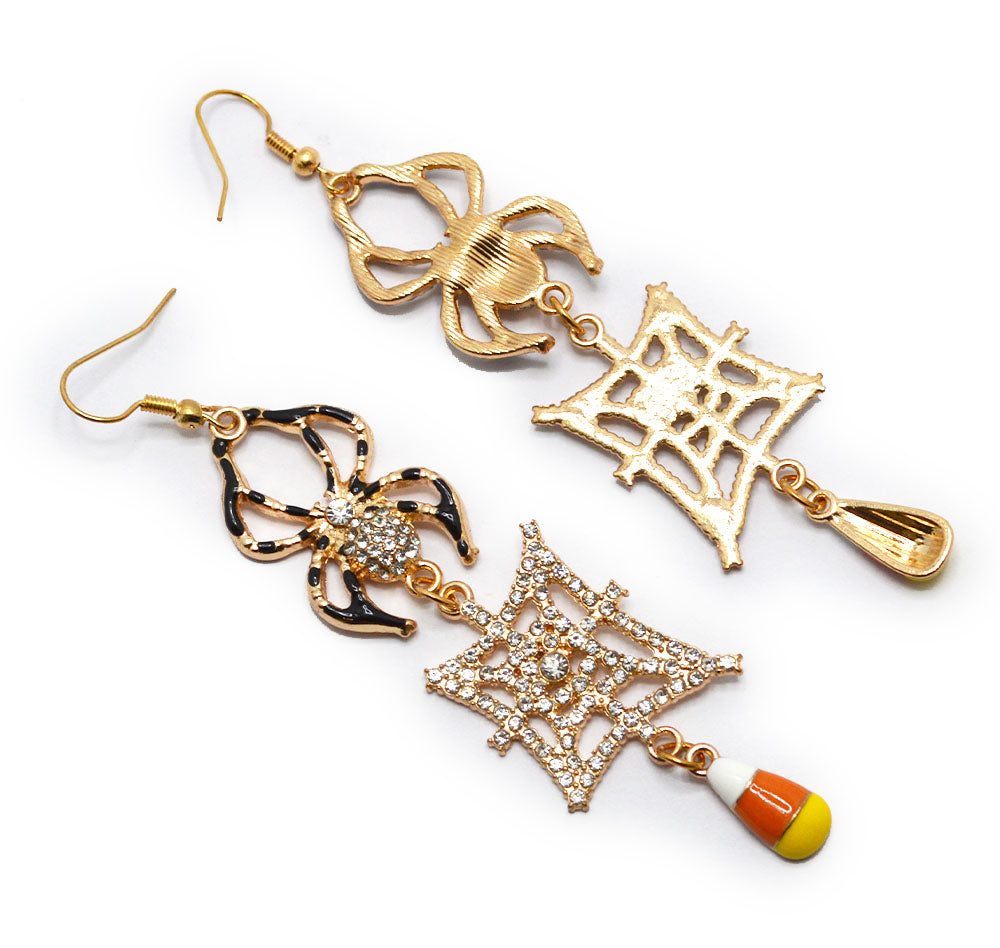 A pair of gold-toned dangle earrings with spider and web motifs, rhinestone accents, and small candy corn charms, shown on a plain white background.