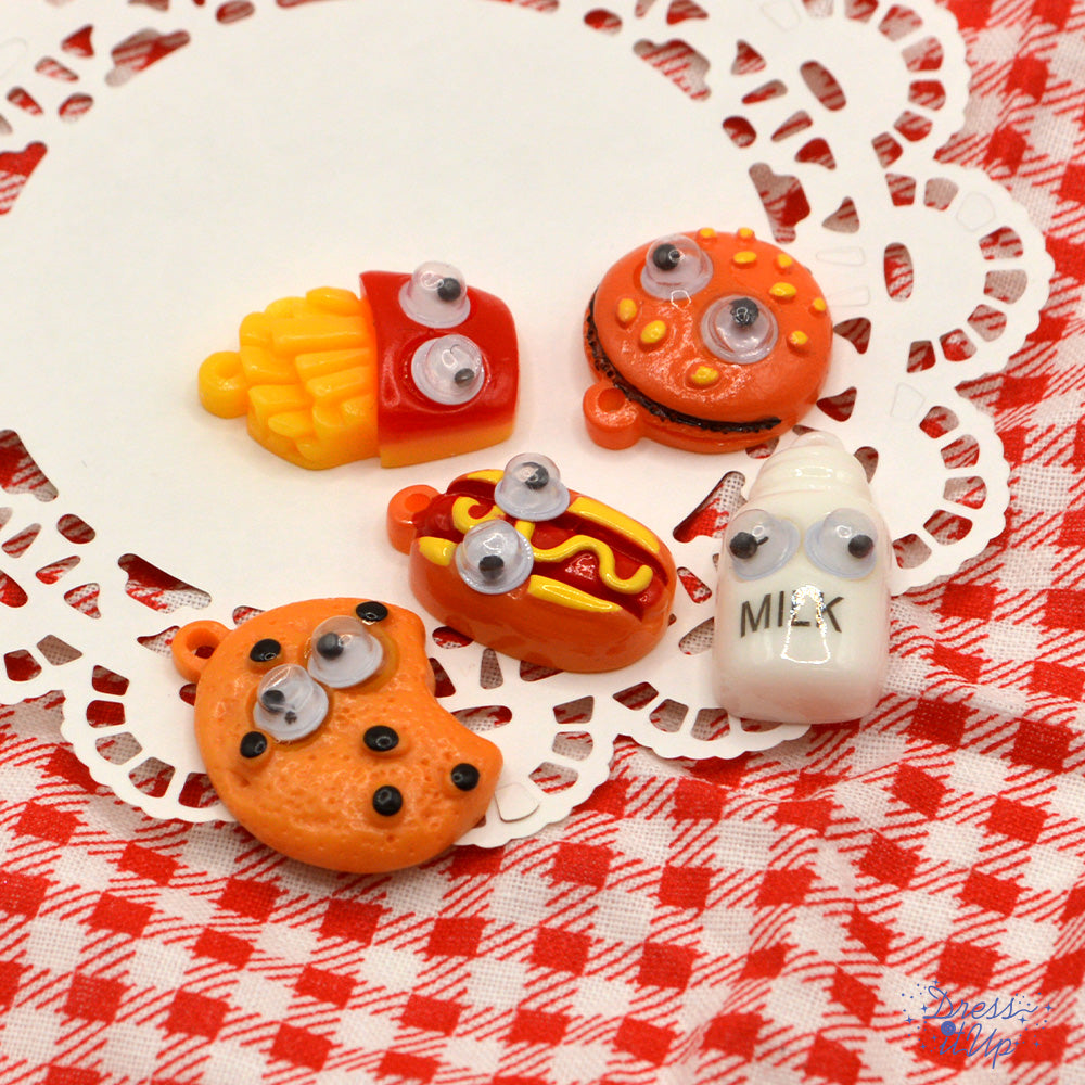 Quirky food with googly eyes. Hamburger, fries, hot dog, cookie and bottle of milk
