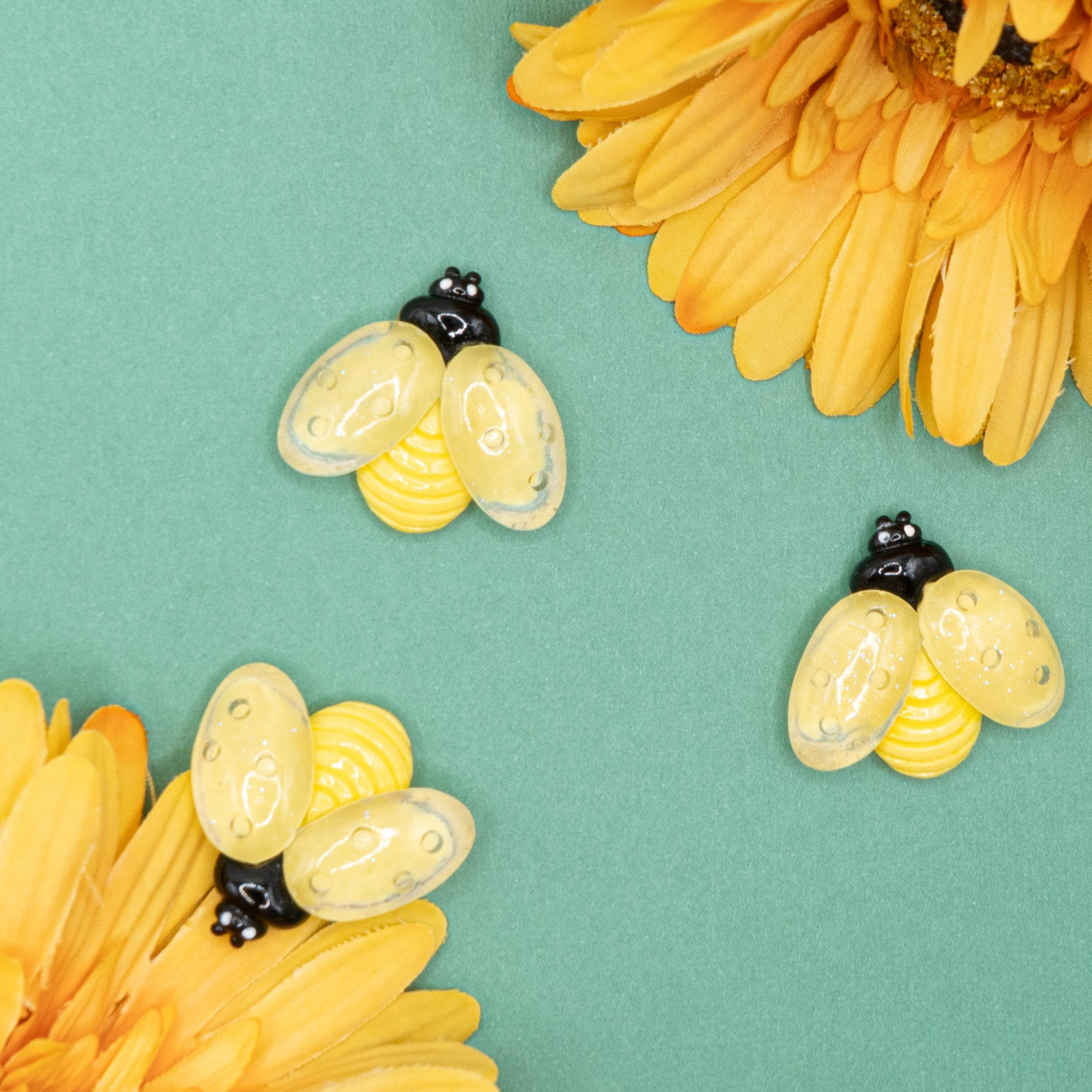 A pack of large resin bees in a mild yellow color for diy crafts