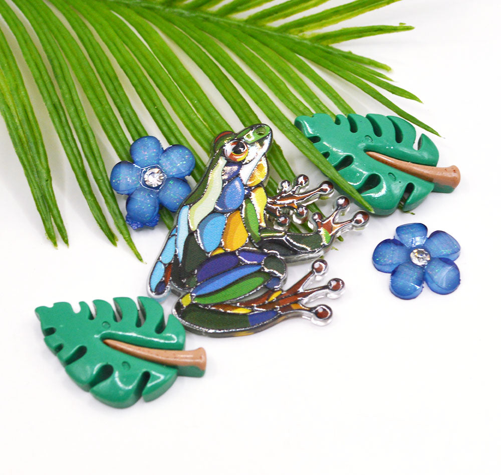 Blue and green frog and tropical flower craft embellishments.