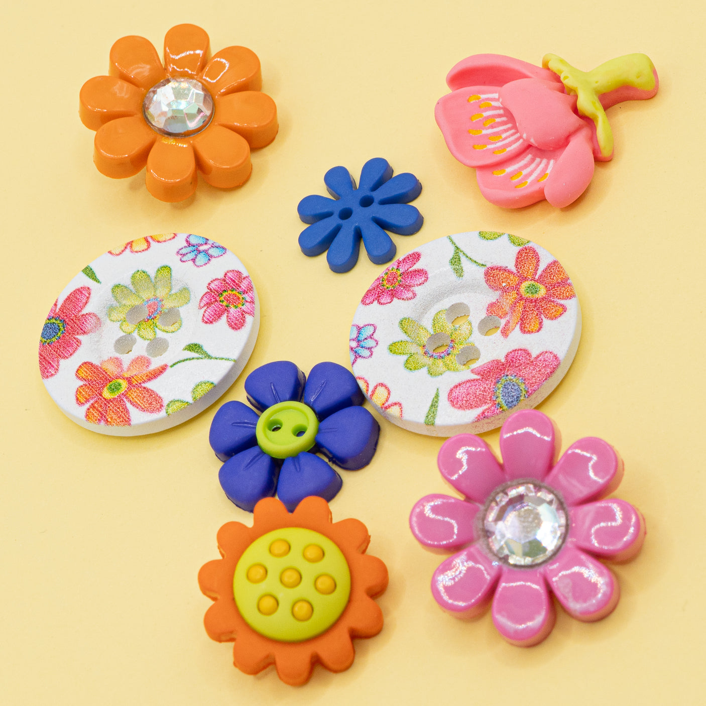 Celebrate spring with this floral craft embellishment pack, featuring sew-thru wood buttons adorned with a charming pink, purple, and orange flower pattern.