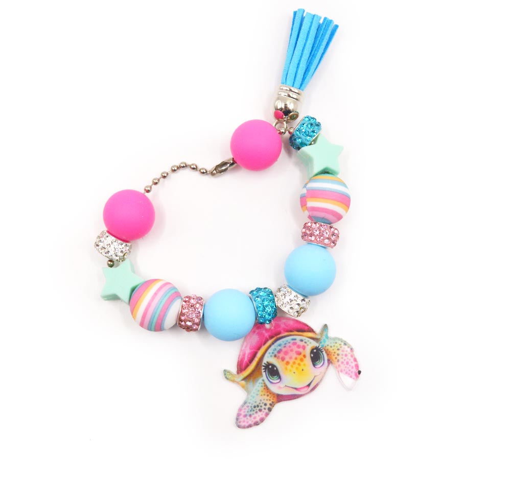 Assortment of silicone girl sea turtle themed beads with charms.