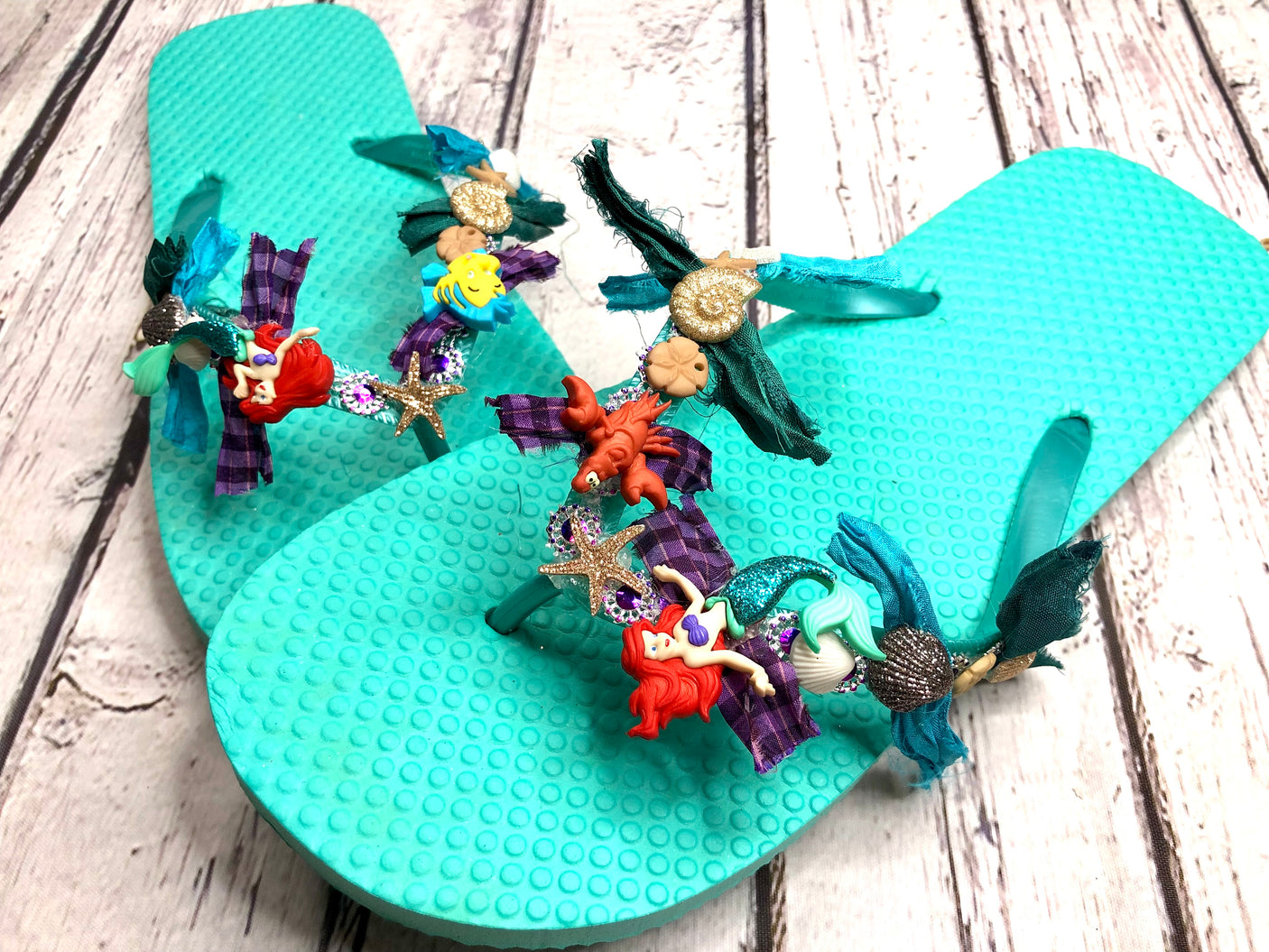 Dress up flip flops with characters from Disney's The Little Mermaid buttons and seashell embellishments