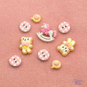 Pink themed embellishments including a rocking horse, teddy bears, hearts and plaid two-hole buttons