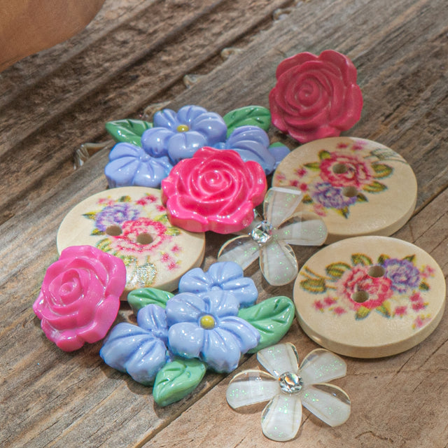 Floral buttons and craft embellishments on wood background