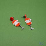 Crafted from lightweight resin, each earring features a whimsical wine glass topped with a playful Santa hat