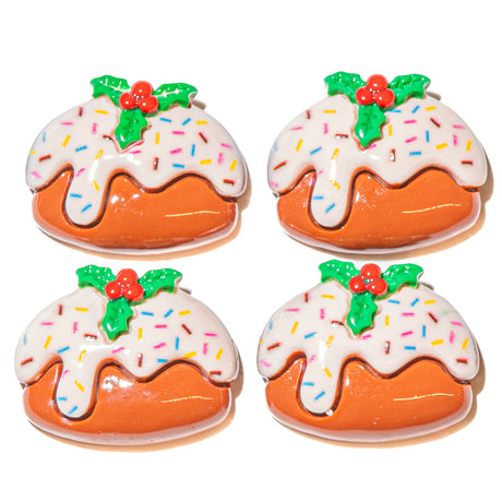 Four Christmas pudding resin craft embellishments shaped like puddings with white icing, colorful sprinkles, green holly leaves, and red berries, arranged in a 2x2 grid on a white background.