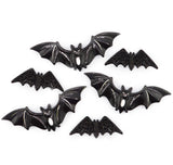 Five black bat-shaped jewelry findings or charms with glittery textured wings, arranged on a plain white background.