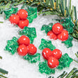 Decorative Christmas embellishments with red berries and green leaves on a snowy background