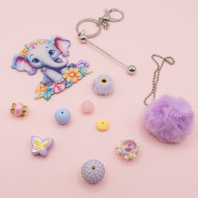this fun kit featuring a large acrylic elephant focal, keyring, pompom, large-hole beads, and spacers