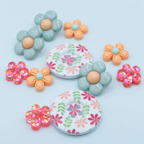 Celebrate spring with this floral craft embellishment pack, featuring sew-thru wood buttons adorned with a charming pink and green flower pattern. The set also includes large blooms and glittery flowers