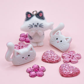 This pack includes a flocked cat charm, pink flowers, and glitter hearts. Perfect for DIY crafts and gifts.