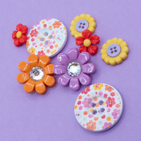 Celebrate spring with this floral craft embellishment pack, featuring sew-thru wood buttons adorned with a charming pink, orange, and purple flower pattern. 
