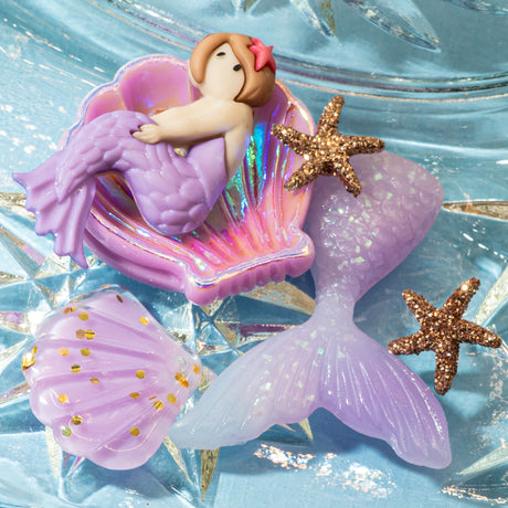 Mermaid embellishment figurine with shell and starfish on a glittery blue background