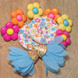 colorful floral buttons and tassel pair on a wooden background