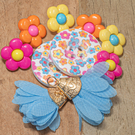 colorful floral buttons and tassel pair on a wooden background