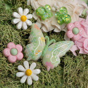 Light green and white butterfly and flower craft embellishments make perfect decorations for wood, paper, and fabric crafts