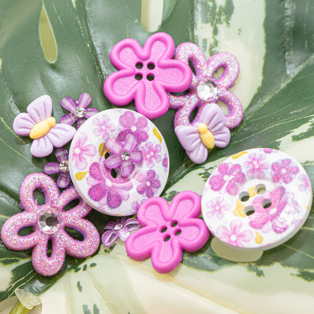 Decorative buttons with floral designs on a leafy background