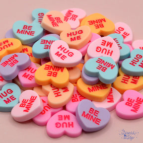 Classic candy conversation inspired heart shaped embellishments with Valentine's Day messages 'Hug Me' and 'Be Mine'