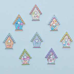 two-hole wood sewing buttons in the shape of pastel birdhouses. 