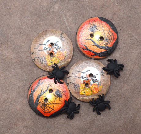 Four round Halloween-themed buttons with spider and spiderweb motifs, arranged on a textured brown background with four small black plastic spiders placed around them.