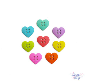Four whole sewing buttons in the shape of large hearts in bright colors